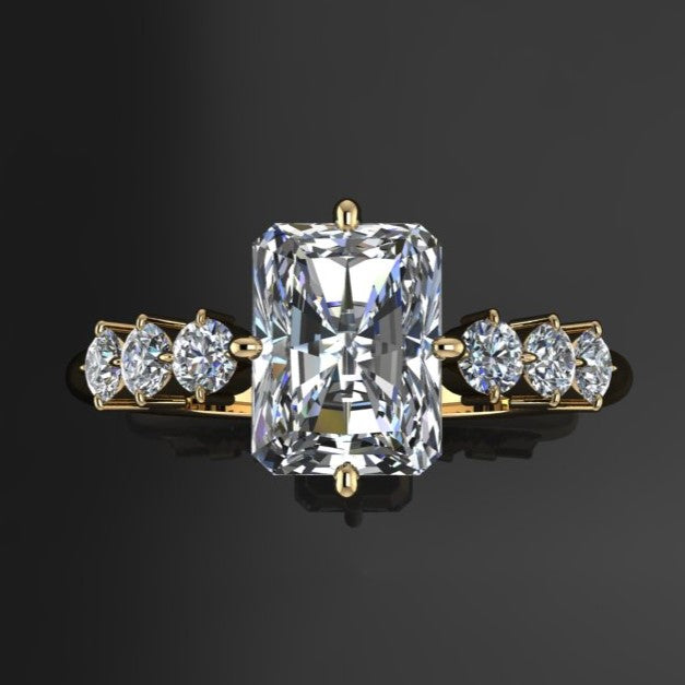 2 carat radiant moissanite center with six nicely sized side stone with prongs set north, south, east, and west - top view