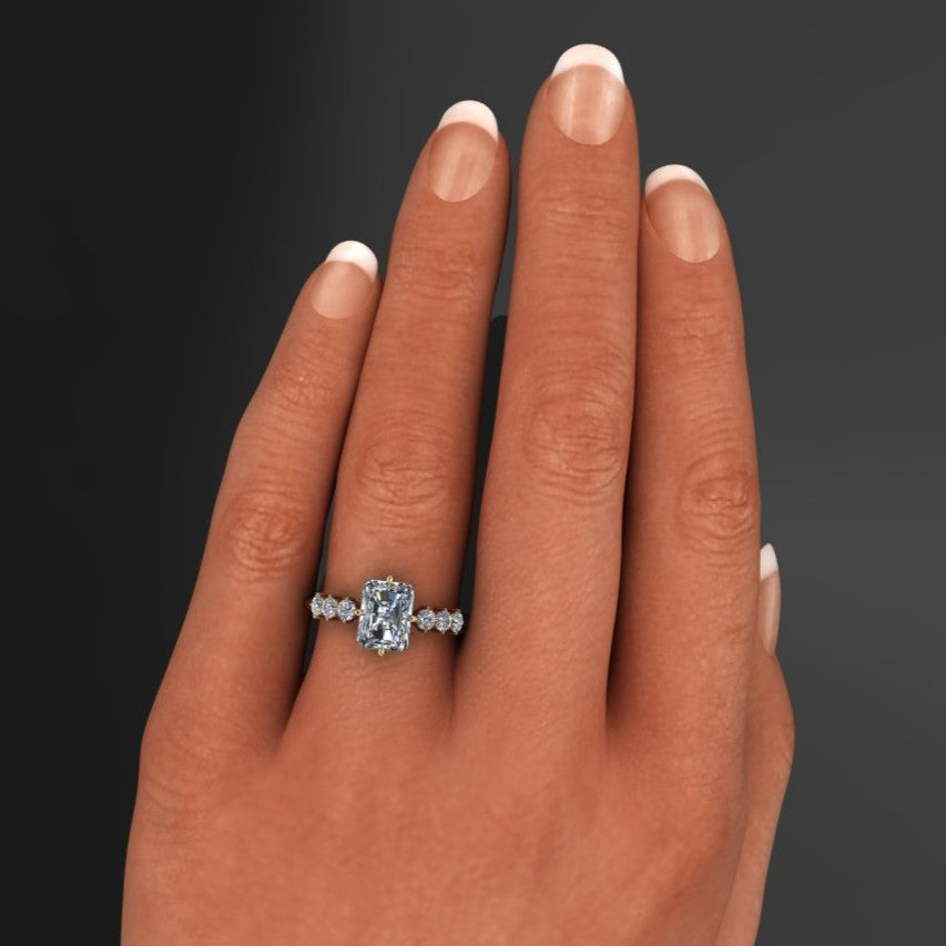 2 carat radiant moissanite center with six nicely sized side stone with prongs set north, south, east, and west - hand model