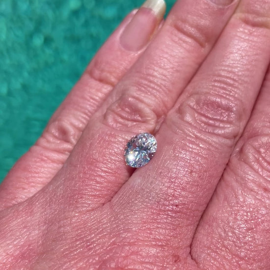 video of an oval moissanite with a swimming pool in the background